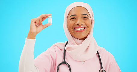 Image showing Nurse, healthcare and vaccine with a muslim woman on a blue background in studio for treatment. Medical, product and insurance with a young female medicine professional holding a glass bottle