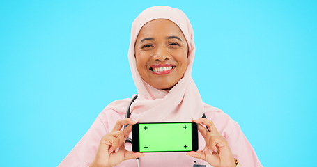 Image showing Phone, green screen and woman doctor isolated on blue background healthcare, tracking marker and mockup space. Face of nurse or muslim person with medical mobile app for advertising video in studio