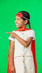 Image showing Face, superhero costume and girl pointing on green screen in studio isolated on a background. Smile, cosplay character and happy child or kid in cape point to mockup, product placement or marketing.