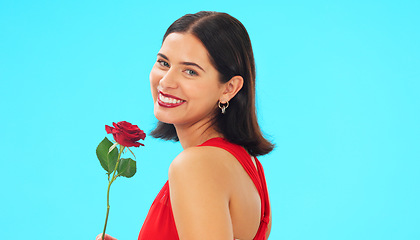 Image showing Face, rose and woman in studio on blue background with fresh, floral or romantic gesture on mockup. Portrait, flower and female with gift, present and romance, valentines or caring offering isolated