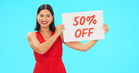 Image showing Sale sign, portrait and woman in studio advertising percentage or discount rate on paper or banner. Smile of a happy female on a blue background for fashion promotion deal, savings or deal and offer