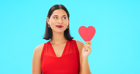 Image showing Paper heart, happy woman and face on blue background, studio and backdrop. Portrait of female model in red dress with shape of love, trust and romance for valentines day, flirting and elegant smile