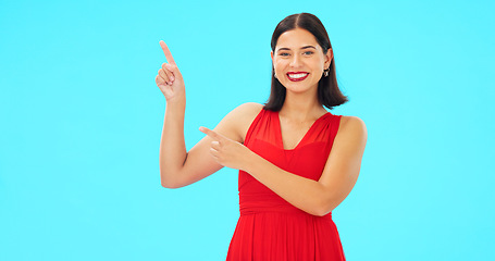 Image showing Smile, face and woman on blue background pointing to mockup, studio and color backdrop. Portrait of happy female model advertising promotion, discount sales or brand presentation of offer coming soon