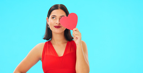 Image showing Paper heart, happy woman and face on blue background, studio and backdrop. Portrait of female model in red dress with shape of love, trust and romance for valentines day, flirting and elegant smile