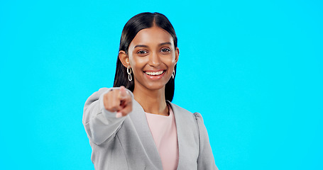 Image showing Portrait, pointing and you with a woman on a blue background in studio for option, selection or choice. Smile, happy and we are hiring with a young female employee in business making a decision