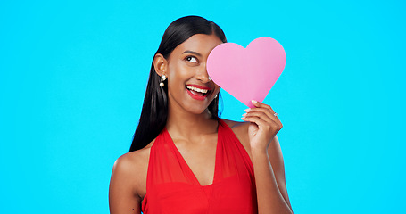 Image showing Thinking, happy or woman with heart paper sign for Valentines Day, studio care and emoji love icon, symbol or poster. Portrait, female beauty or person contemplating secret admirer on blue background