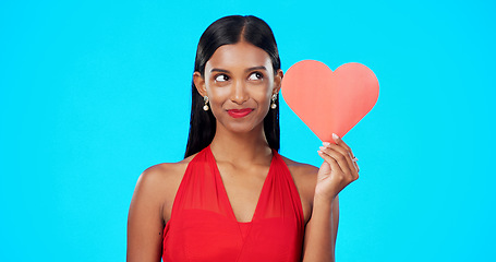 Image showing Thinking, happy or woman with heart paper sign for Valentines Day, studio care and emoji love icon, symbol or poster. Portrait, female beauty or person contemplating secret admirer on blue background