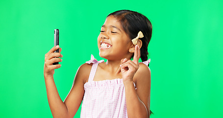 Image showing Child, peace and smile for selfie on green screen background for happiness and motivation in studio. Face of happy girl kid with technology for profile picture of connection with hand sign or emoji