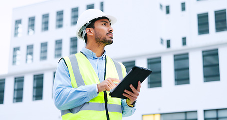 Image showing Male engineer checking data on digital tablet and inspecting construction site. Technician in a hardhat doing management and project planning outdoors. Skilled worker looking or overseeing operations