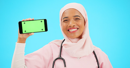 Image showing Phone, green screen and doctor woman isolated on blue background for healthcare tracking marker and mockup space. Face of nurse or muslim person with medical mobile app for advertising in studio