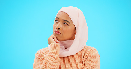 Image showing Muslim woman, thinking and idea with hand on face for mockup, advertising or thought. Serious islamic female with hijab and emoji for doubt, sad and to think about option on a studio blue background