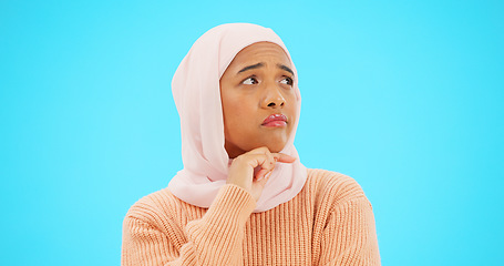 Image showing Muslim woman, thinking and idea with hand on face for mockup, advertising or thought. Serious islamic female with hijab and emoji for doubt, sad and to think about option on a studio blue background