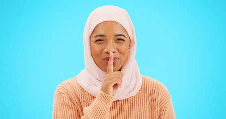 Image showing Muslim woman, finger on lips and secret with hand on mouth for mockup, advertising or promotion. Islamic female with hijab, face emoji or laugh for sale, gossip or surprise on studio blue background