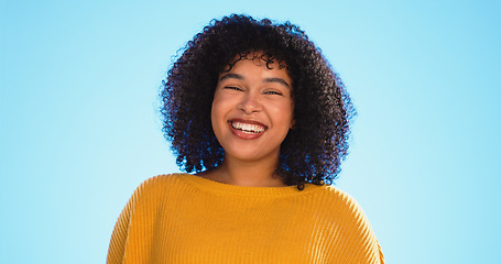 Image showing Face, funny and black woman with smile, excited and cheerful against a blue studio background. Portrait, African American female and lady with freedom, laughing and carefree with happiness and joyful