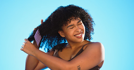 Image showing Frustrated, knot and black woman with comb for hair on blue background with problem, hairstyle frizz and damage. Beauty salon, hairdresser and sad girl brush afro for wellness, grooming and cosmetics