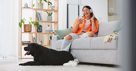 Image showing Phone, headphones and laughing woman with dog on sofa in home living room. Comic, relax and happy female streaming music, radio or podcast with smartphone while playing with animal, pet or bonding.