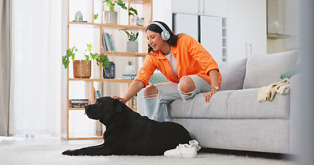 Image showing Phone, headphones and laughing woman with dog on sofa in home living room. Comic, relax and happy female streaming music, radio or podcast with smartphone while playing with animal, pet or bonding.