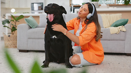 Image showing Black dog scratch, woman and living room with animal and pet owner care in a home. Headphones, gen z person and labrador in a house with happiness and a smile listening to music with puppy love