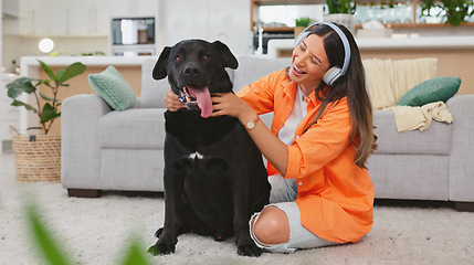Image showing Headphones, dog petting and woman in a living room feeling puppy love from pet care in a home. House, animal and young female listening to music with happiness and bonding from labrador attention