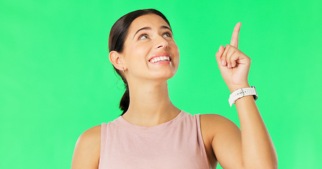 Image showing Happy, woman face and pointing up to show promotion and product placement in green screen. Happiness, smile and model gesture to advertising and commercial deal in isolated studio background