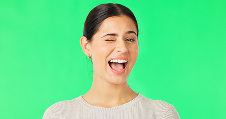 Image showing Happy, woman and winking face on green screen, studio and color background. Portrait, female model and smile for wink, secret and cool girl in fun mood, personality and happiness for flirting emoji