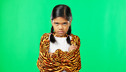 Image showing Girl child, angry face and green screen studio with arms crossed, refuse or shake head in tiger pyjamas. Frustrated kid, anger or portrait for mock up with mad, tired or bored expression by backdrop