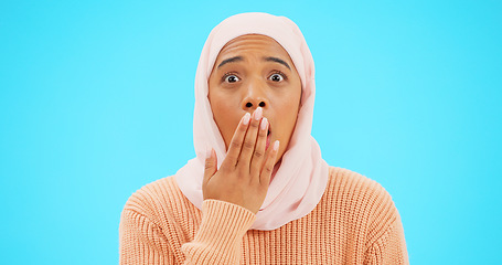 Image showing Muslim woman, omg and surprise with hand on mouth for mockup, advertising or promotion. Islam female with hijab and face emoji for reaction to sale, gossip or secret on a studio blue background