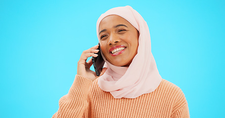 Image showing Phone call, talking and communication with muslim woman in studio for networking, contact and conversation. Connection, technology and chatting with female on blue background for discussion and news