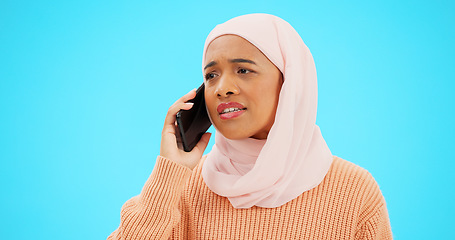 Image showing Muslim woman, phone call and angry, argument or conflict in studio isolated on a blue background mockup. Cellphone, discussion and frustrated Islamic person talking, upset and speaking or question.