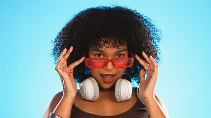 Image showing Trendy, gen z and face of a black woman in a studio with accessories, sunglasses and fashion. Happy, afro and portrait of African female model with a cool, stylish and edgy style by a blue background