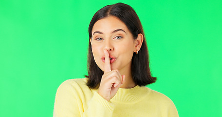 Image showing Wink, secret and face of a woman on a green screen isolated on a studio background. Quiet, silent and portrait of a winking girl with finger on mouth for silence, privacy and gossip on a backdrop