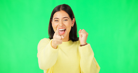 Image showing Happy woman, celebration and pointing on green screen for winning, success or promotion against a studio background. Portrait of excited female in joy with finger point for choice on chromakey mockup