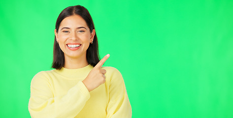 Image showing Portrait, pointing and product placement with a woman on green screen in studio for marketing or advertising. Hand gesture, product placement and options with an attractive young female on chromakey