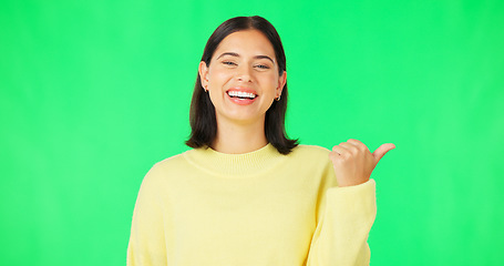 Image showing Portrait, pointing and green screen with an advertising woman in studio for marketing or product placement. Hand gesture, product placement and options with an attractive young female on chromakey