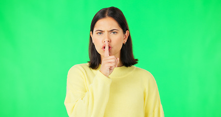 Image showing Secret, green screen and face of serious woman in studio, finger and lips on background for privacy. Portrait, angry female model and silence of noise, shush on mouth and quiet for confidential emoji