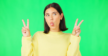 Image showing Green screen, funny face expression and happy woman posing with tongue out, peace sign and carefree personality. Portrait, female model and smile in studio with emoji reactions, meme and happiness