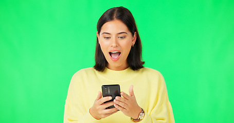 Image showing Happy woman, phone and celebration on green screen for winning, promotion or bonus against a studio background. Portrait of excited female in joyful happiness on smartphone for win or prize on mockup