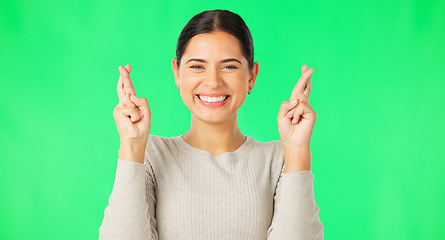 Image showing Excited woman, fingers crossed and face on green screen, background and studio for good luck. Portrait of happy female model hope for winning prize, wish and optimism with emoji sign, hands and smile