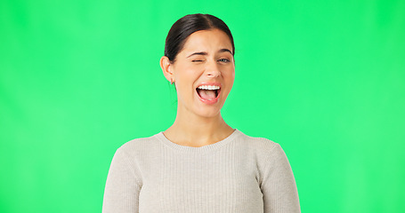 Image showing Happy young woman, face and wink on green screen, studio and color backdrop. Portrait, female model and smile for blink, secret and cool girl in fun mood, personality and happiness for flirting emoji