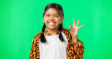 Image showing Children, perfect and hand gesture with a girl on a green screen background in studio feeling good. Portrait, smile and emoji with an adorable happy female child on chromakey mockup looking positive