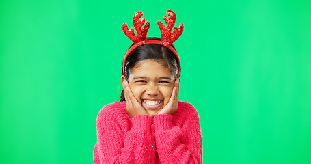 Image showing Face, Christmas horns and girl excited, green screen and happiness against a studio background. Portrait, young person and female child with smile, Xmas and surprise with excitement, joy and cheerful