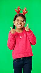 Image showing Child portrait, christmas and thumbs up on green screen for motivation or mindset. Smile of girl kid on studio background with antlers headband excited for holiday celebration thank you or like emoji