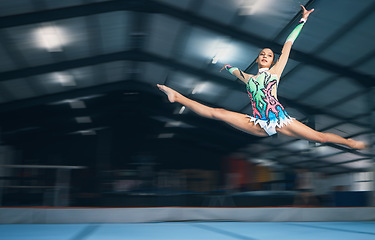 Image showing Fitness, gymnastics and girl in arena jumping for competition sport, exercise and training with mockup space. Sports, movement and jump, professional woman gymnast in form and balance in performance.