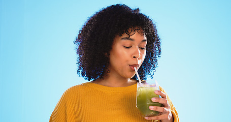 Image showing Green juice, black woman drinking and healthy smoothie of a person with weight loss drink. Studio, blue background and female with vegetable, nutrition and detox fruit shake for health and wellness