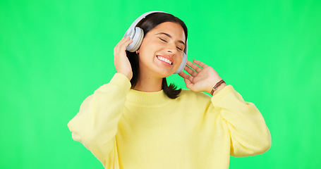 Image showing Face, green screen and woman with headphones, listen and movement on a studio background. Portrait, female dancer and person with headset, streaming music and excitement with stress relief and relax