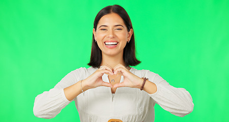Image showing Heart, hands and face of woman smile on green screen, studio or happy on studio backdrop. Portrait of female model, finger shape and love of support, thank you and emoji sign of kindness, care or joy