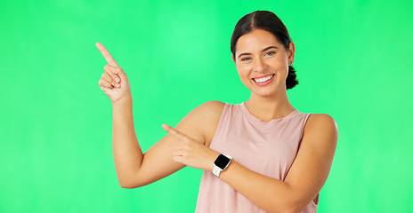 Image showing Woman face, hands pointing and green screen with happiness and smile showing advertisement. Portrait, isolated and studio background with a happy young female point to show mock up announcement