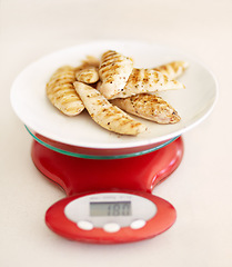 Image showing Protein, diet and chicken breast on a scale in studio from above on a table in the kitchen for health or wellness. Food, meat and nutrition with healthy organic lunch on a plate to measure the weight