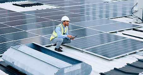 Image showing Engineer or contractor measuring solar panels on a roof of a building. Engineering technician or electrician installing alternative clean energy equipment and holding a tablet to record measurements