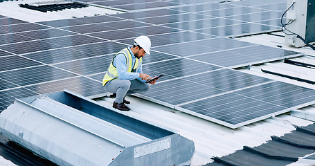 Image showing Engineer or contractor measuring solar panels on a roof of a building. Engineering technician or electrician installing alternative clean energy equipment and holding a tablet to record measurements